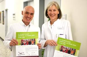 Tjhen und Strunk mit Plakat für den Charitylauf