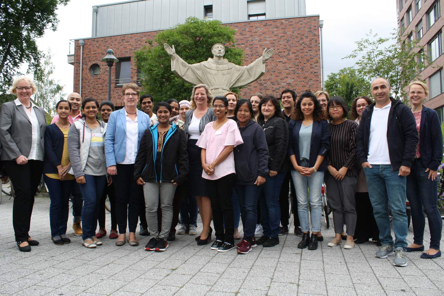 Die Teilnehmenden des ersten Qualifizierungskurses für zugewanderte Pflegepersonen vor dem St. Franziskus-Hospital Münster – zusammen mit Projektleiterin Dr. Gertrud Bureick (l.), Schulleiterin Ruth Adrian (6.v.l.) und Stiftungsvorstand Dr. Daisy Hünefeld (M.).