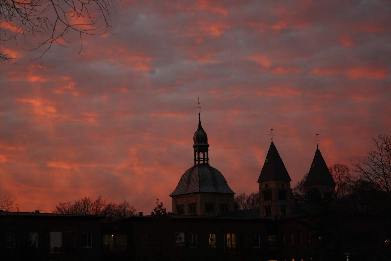 Blick vom Torhaus der Franziskus Stiftung auf die Mauritz-Kirche im Abendrot.