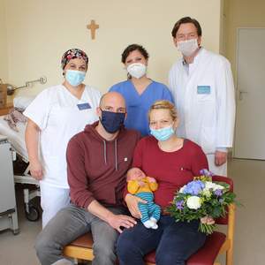 Chefarzt Dr. Torsten Frambach (rechts), Hebamme Marina della Ragione (Mitte) und Kinderkrankenschwester Sükram Ersoy (links) gratulieren dem Ehepaar Mann stellvertretend für die Geburtshilfe zur Geburt ihres Sohnes Moritz.