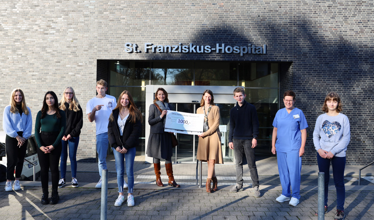 Das St. Franziskus-Hospital Ahlen gewann mit dem eingereichten Projekt „Mutmach-Tüten“ der Fritz-Winter-Gesamtschule Ahlen den diesjährigen kkvd Sozialpreis 2021. Der Preis ist mit 1000,- € dotiert und wurde am Dienstag der Fritz-Winter-Gesamtschule überreicht. (v.l.n.r.) Lilli-Sophie Krampe-Hüttmann, Evelin Aksan, Vivien Halbig, Paul-Leander Quittek, Vivien Dasler, Birgit Beckmannshagen, Anja Rapos, Ben-Marten Quittek und Theresa Perk.